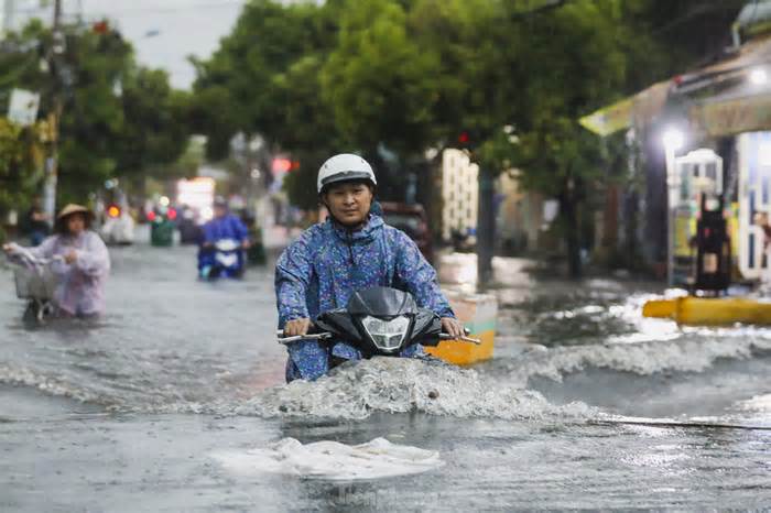Người dân chật vật vượt biển nước về nhà sau mưa lớn ở TPHCM