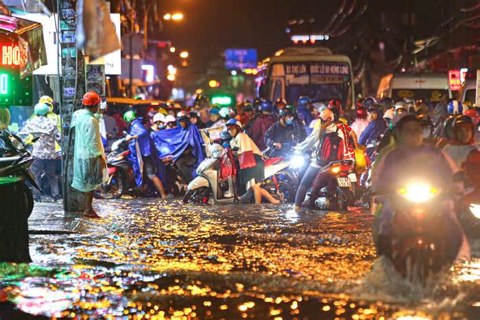 Quốc lộ 50 đoạn qua TPHCM ngập nặng, người dân vật vã về nhà