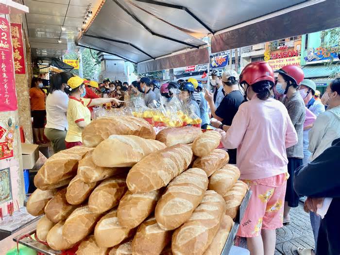 Xếp hàng từ tờ mờ sáng để mua heo quay cúng Thần Tài