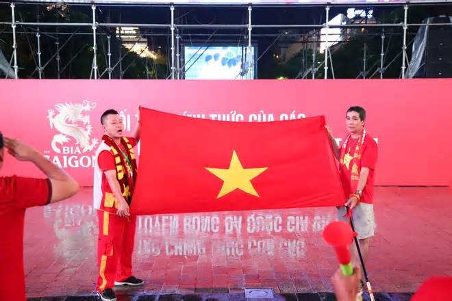 CĐV TP.HCM đội mưa xem Việt Nam đấu Malaysia ở phố đi bộ Nguyễn Huệ