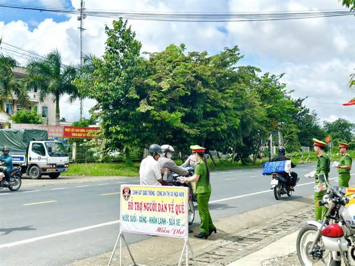 Cảnh sát giao thông Sóc Trăng tặng nước, áo mưa, sửa xe cho người dân về quê nghỉ lễ