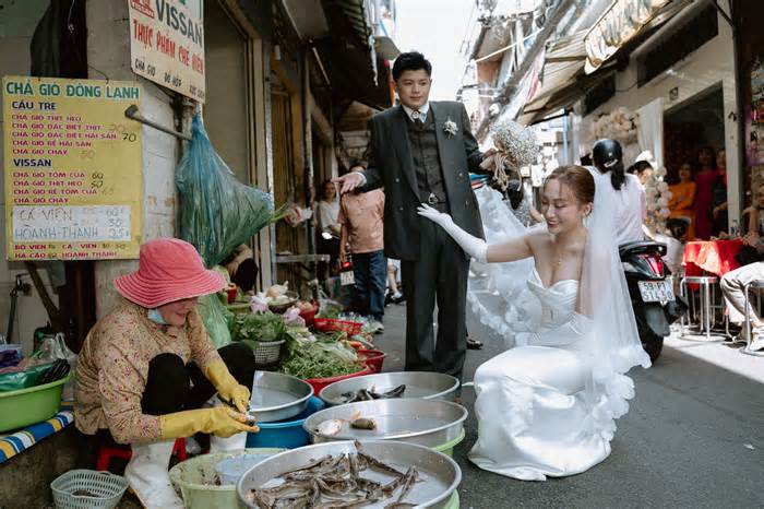 Cô dâu chú rể chụp ảnh cưới trong chợ, lựa cá, mua rau