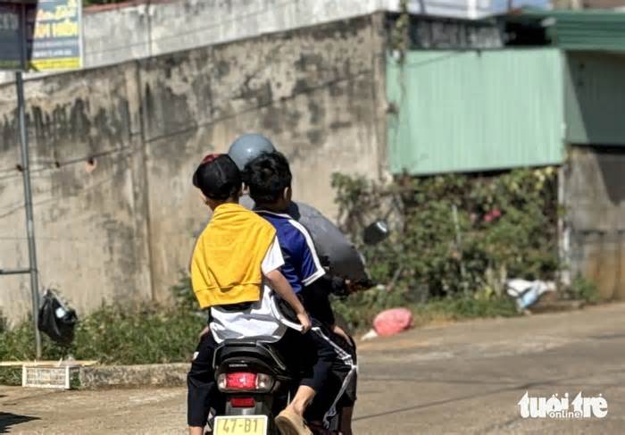 Vẫn chở ba, không mũ bảo hiểm phóng nhanh trước cổng trường