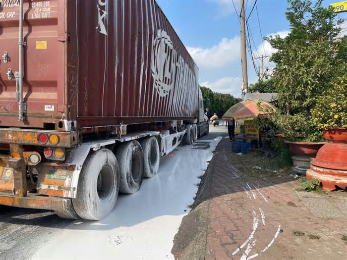 Xe container bất ngờ lật ở vòng xoay, sơn đổ trắng mặt đường lúc rạng sáng