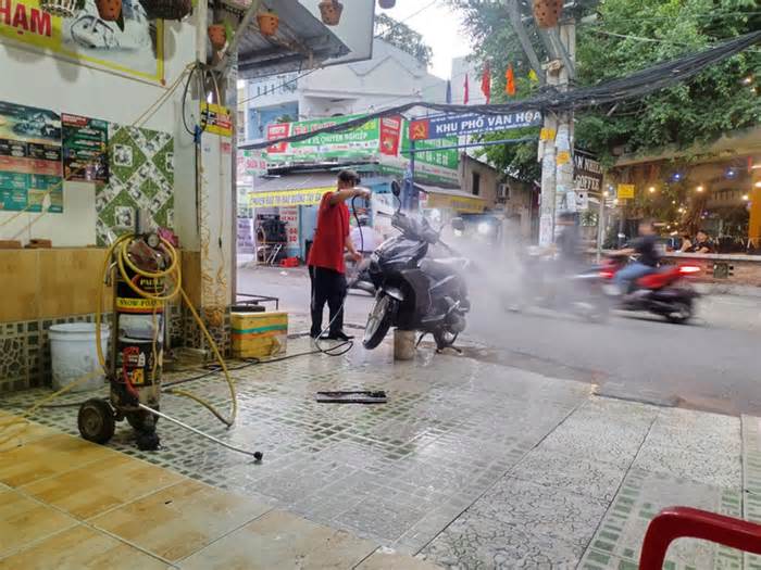 Tiệm rửa xe bắn nước tung tóe vào người đi đường, thải chất bẩn xuống cống