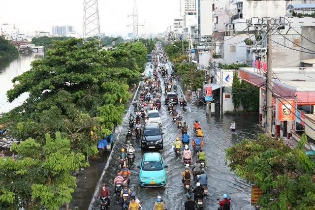 TPHCM: Triều cường dâng cao khiến đường sá ngập sâu, người dân chật vật đi lại