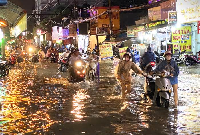 Người dân TPHCM vật vã lội nước về nhà trong đêm sau mưa lớn