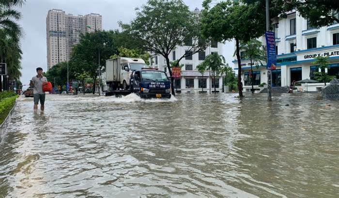 Đường ngập sâu sau mưa lớn, người Hà Nội lội nước đi làm