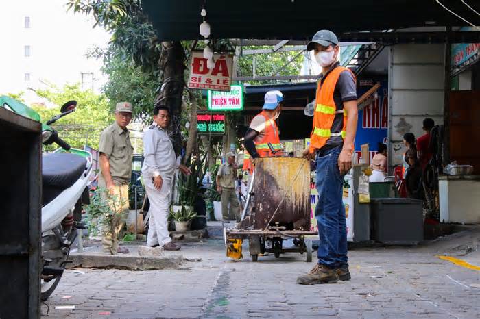 Người dân hỗ trợ lực lượng chức năng kẻ vạch, phân định vỉa hè dành cho người đi bộ