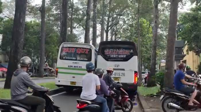 Hai xe khách dừng chắn hết làn đường ở TPHCM, nhiều xe máy phải leo vỉa hè