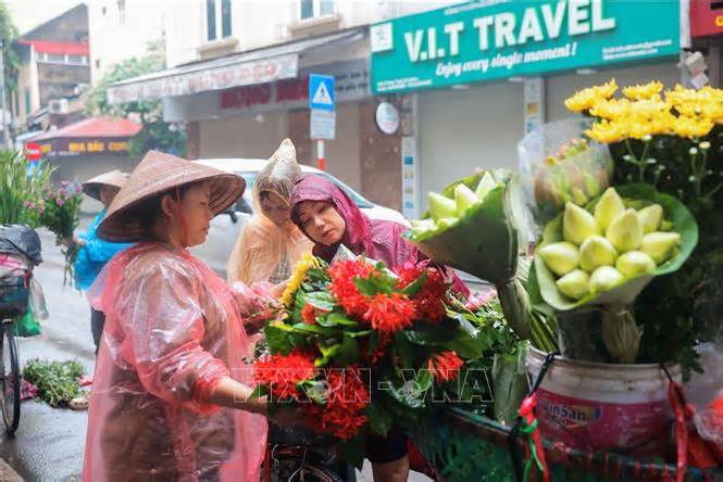 Người dân Hà Nội đội mưa đi mua sắm trong Tết Đoan Ngọ