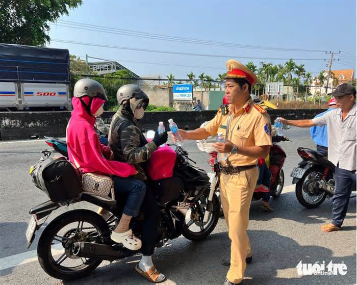 Cảnh sát giao thông phát nước cho người dân về quê ăn Tết