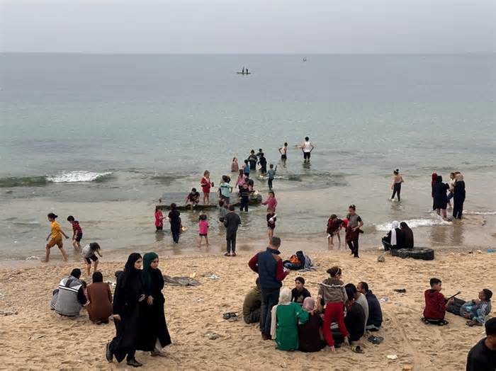 Trẻ em chơi đùa trên bãi biển Gaza khi tiếng súng lặng im