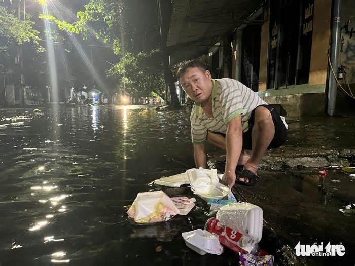 Đường phố Tuy Hòa ngập nặng sau trận mưa dông, dân tự móc rác khơi thông miệng cống