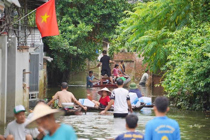 Người dân vùng lũ Chương Mỹ chèo thuyền tiếp nhận đồ hỗ trợ