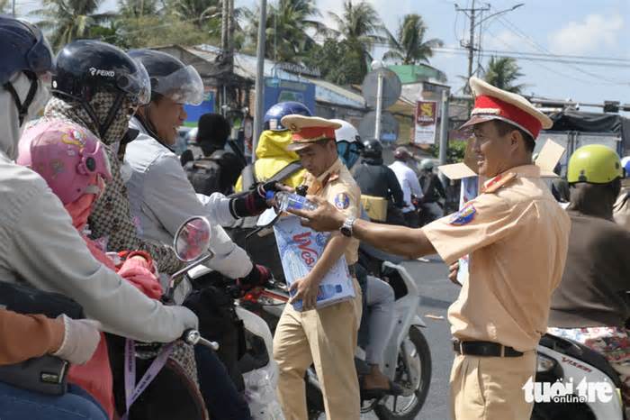 Cảnh sát ra quốc lộ 1 phát nước uống, khăn lạnh cho người dân về quê nghỉ lễ