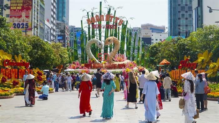 Nắng oi bức, người dân vẫn tranh thủ 'check-in' đường hoa Nguyễn Huệ ngày cuối