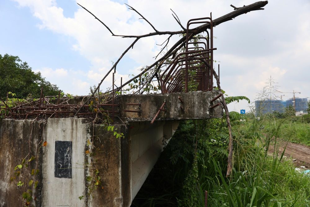Xung quanh công trình rác thải vứt bừa bãi, cây dại phủ kín, và kết cấu sắt thép có dấu hiệu hoen gỉ. Ảnh: Anh Tú