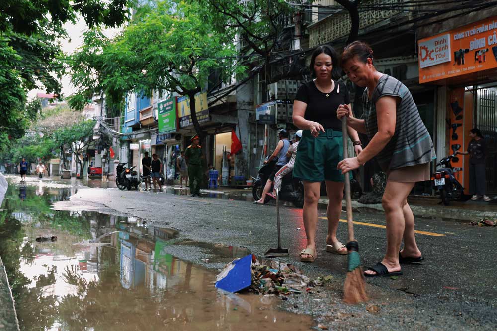 Hà Nội: Nơi đóng cửa im lìm, nơi hối hả dọn dẹp sau lũ