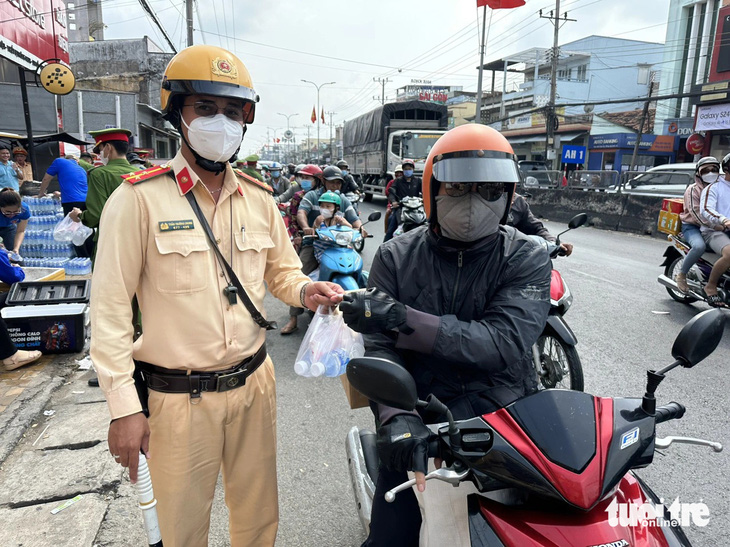 Cảnh sát giao thông phát nước, khăn lạnh miễn phí cho người dân về quê ăn Tết