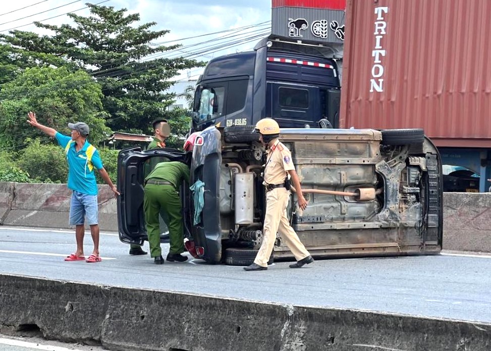 Giải cứu 5 người trong ‘xế hộp’ lật giữa quốc lộ sau va chạm với xe container